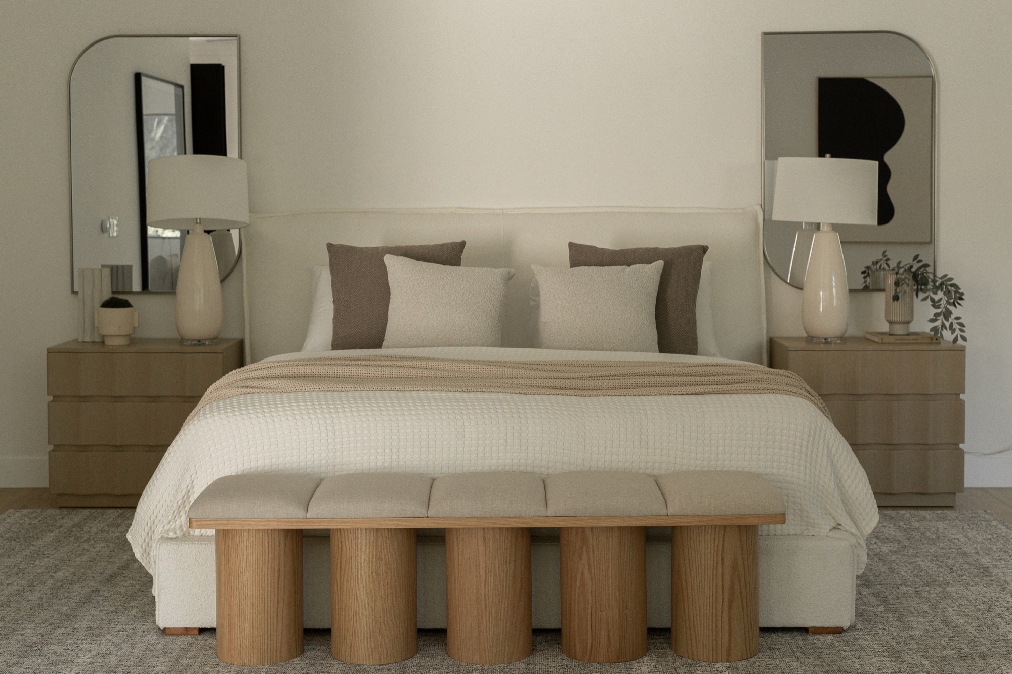 Primary bedroom, upholstered bed flanked by nightstands and mirrors