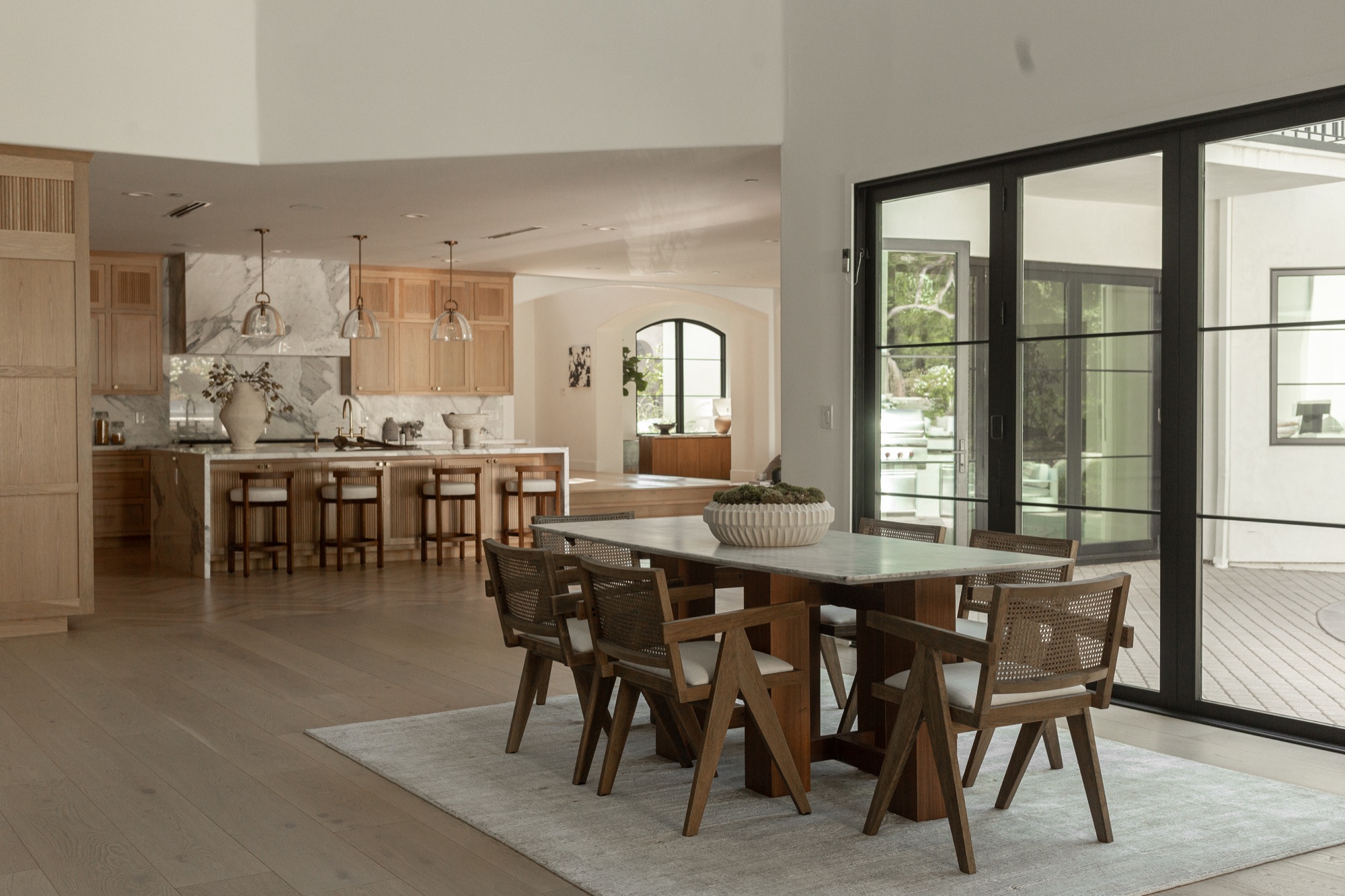 Breakfast nook, table set beneath a pendant light with doors to the deck