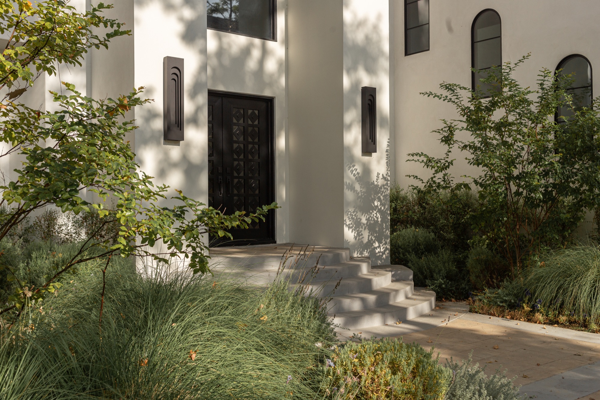 Front door, wood panel entry with sconces and stone steps
