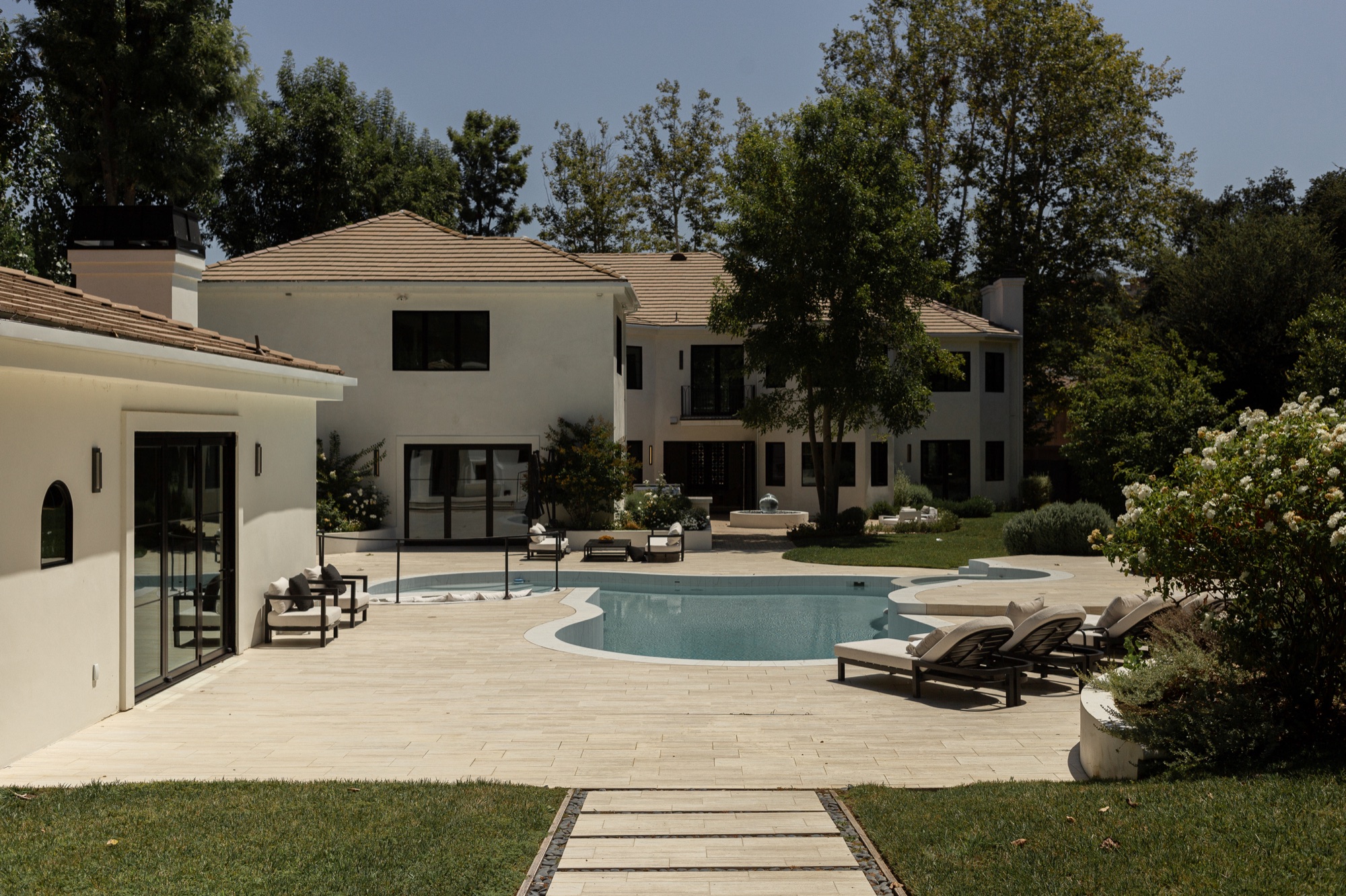 Rear exterior, symmetrical view of the house and pool