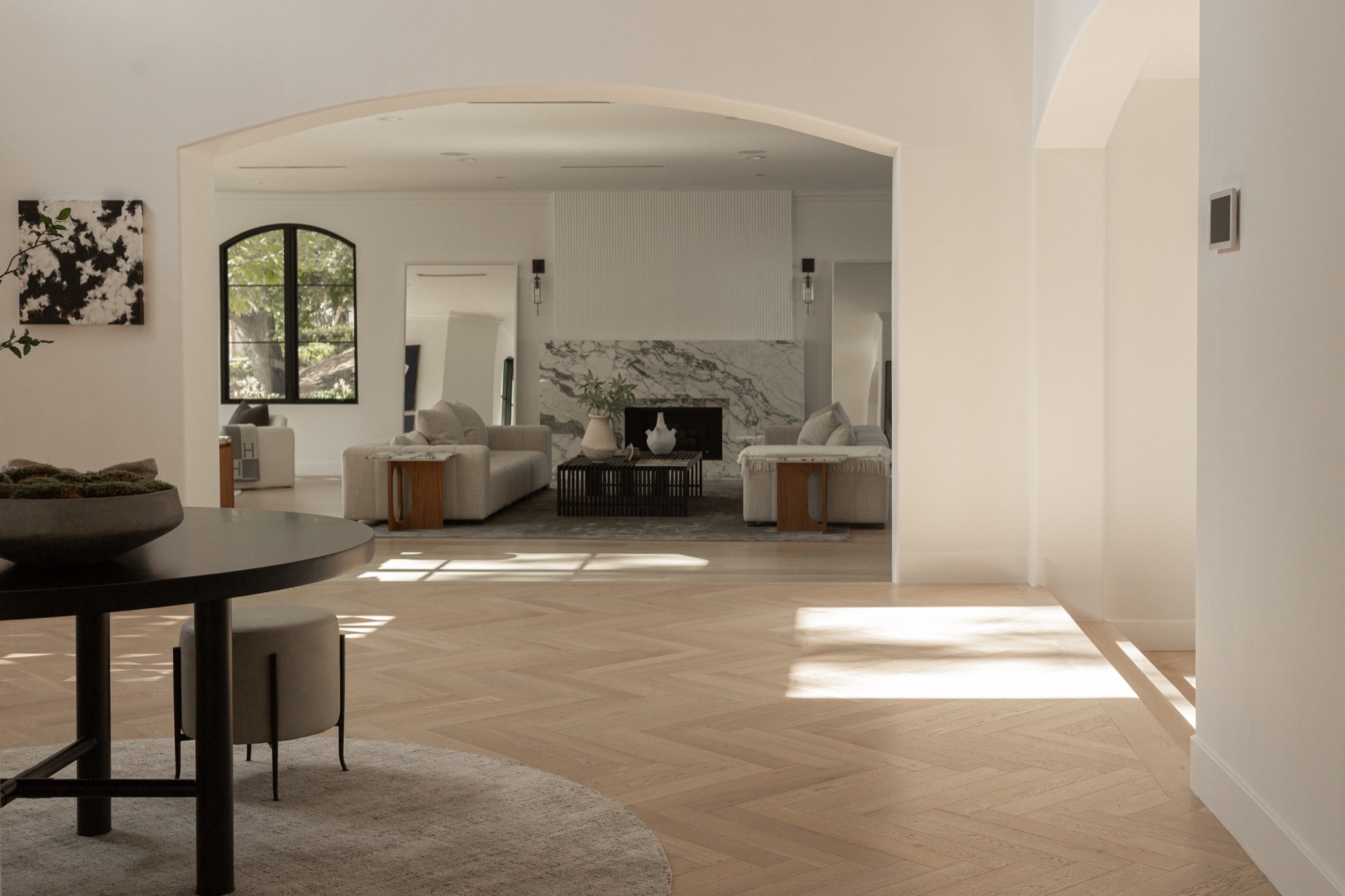 Living room, wide, arched openings toward the dining area and yard